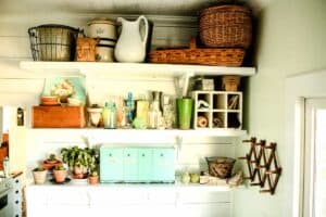 farmhouse laundry room open shelves with vintage baskets potted plants glass jars and laundry items