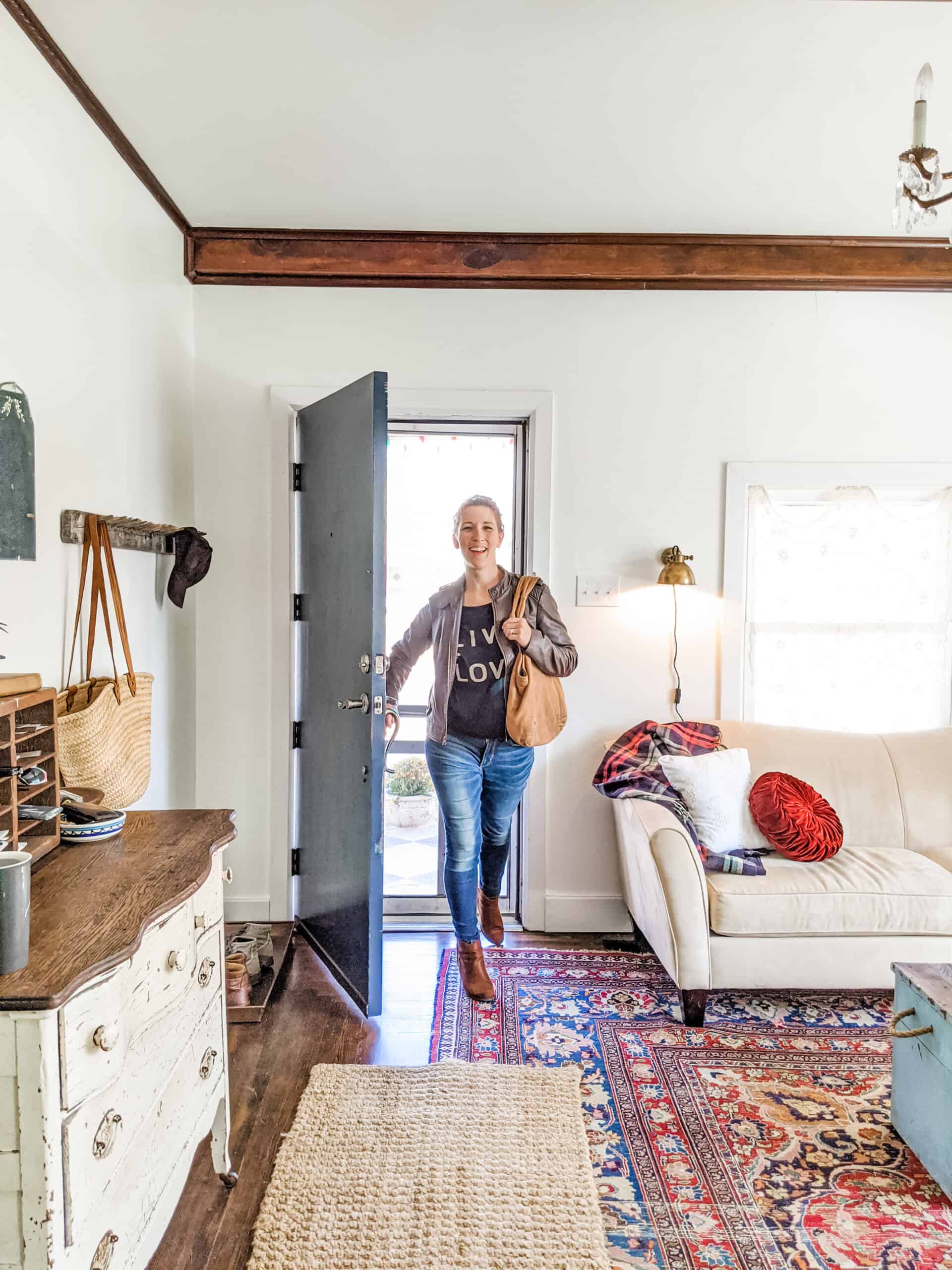 woman entering front door of her bungalow home with vintage decor