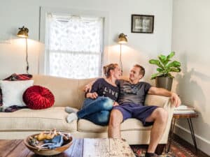 young couple lounging on living room couch with authentic vintage home decor
