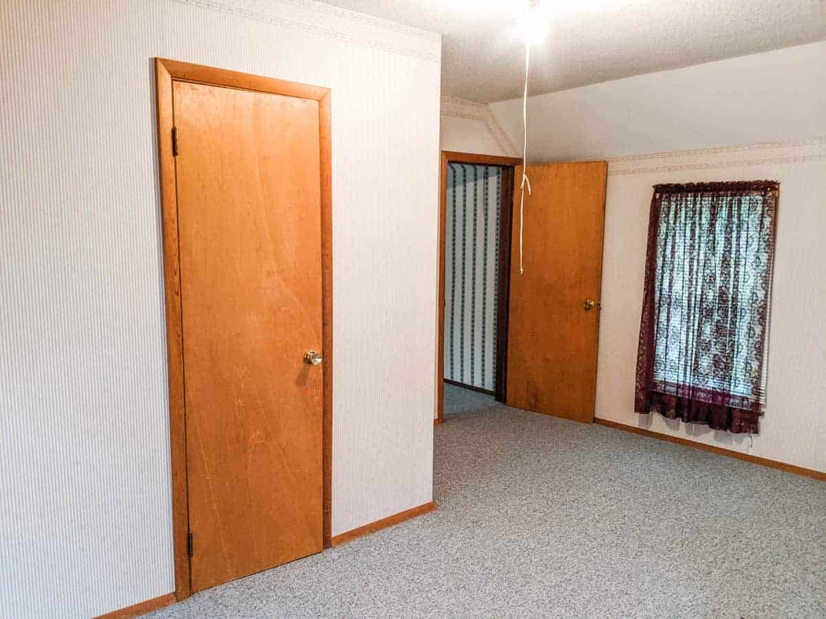 farmhouse upstairs bedroom with angled ceiling carpeted floor a closet door room door and one window