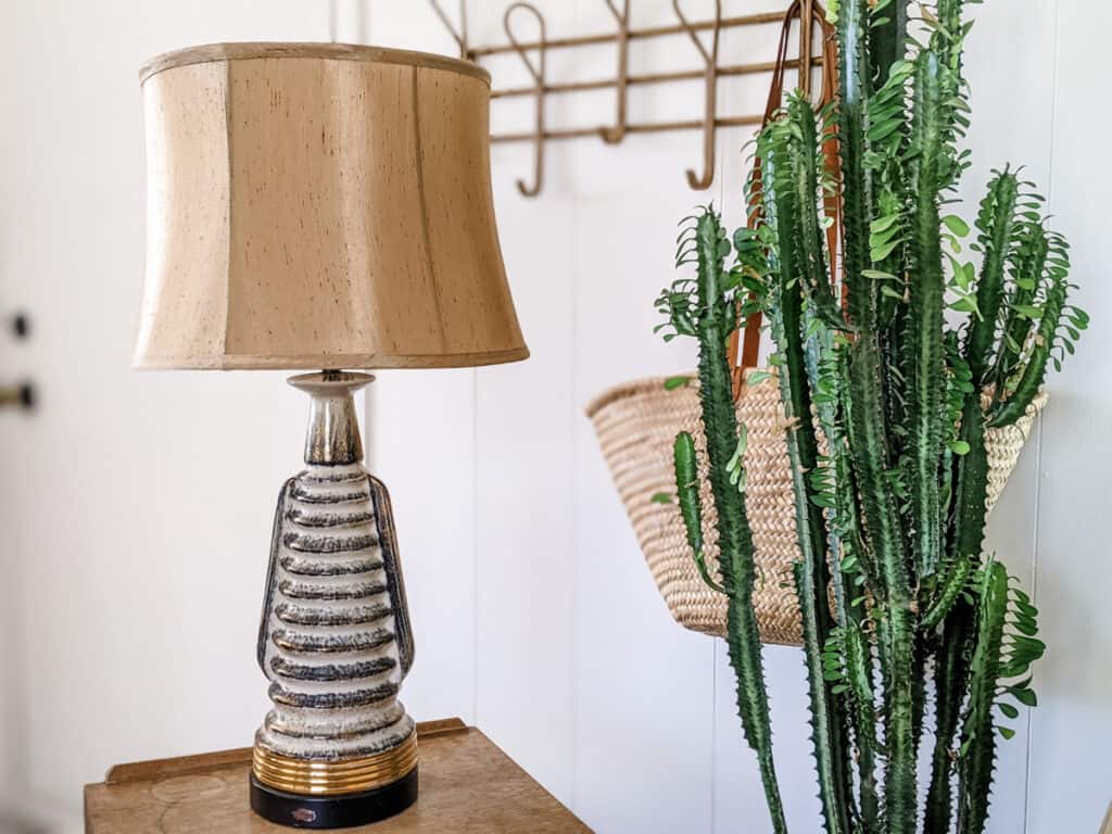 mid century modern lamp on mid century nightstand with plant and basket decor in mobile home