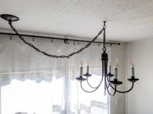 black modern farmhouse chandelier hanging above kitchen table of mobile home