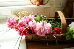 shallow flat basket filled with garden flowers on kitchen counter
