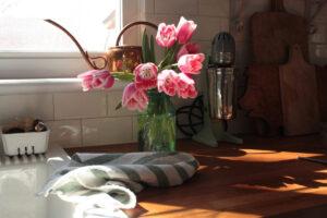 vase of pink tulips on farmhouse butcher block countertop