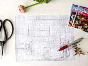 blueprint for designing a cut flower garden surrounded by seed packets pen scissors and cut peony