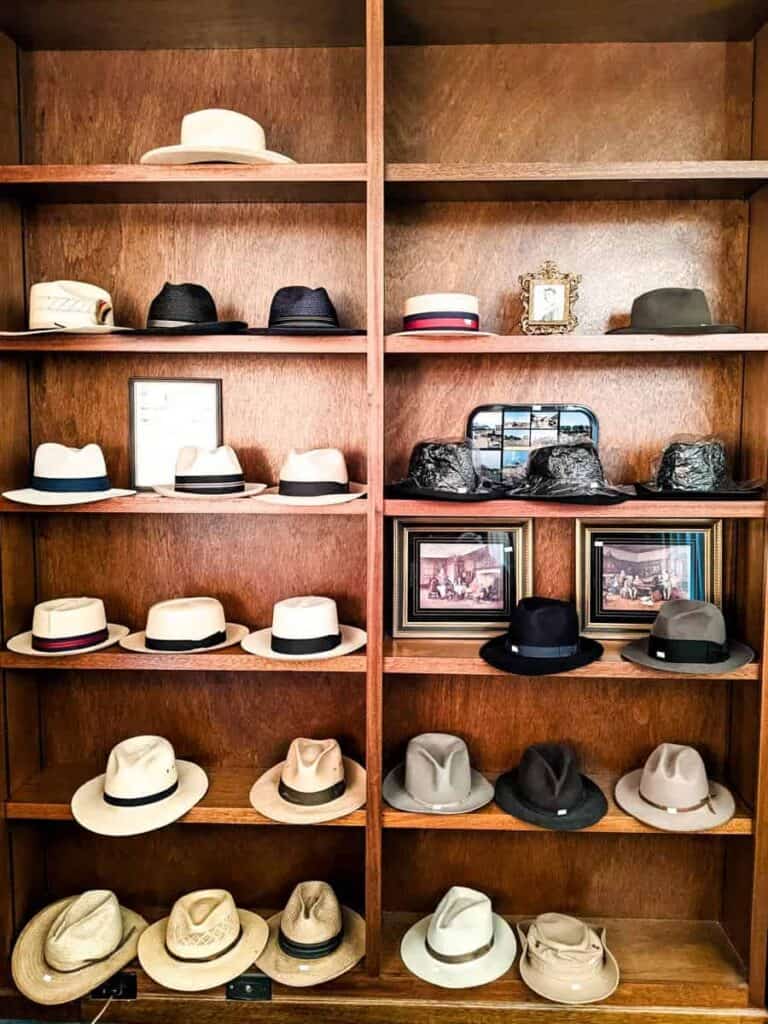 built in wooden shelving unit with collection of 27 vintage hats for men