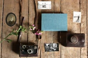 vintage camera book and photographs against wood slat background