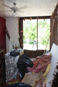 bungalow bedroom in the midst of remodeling with wall opening for new window