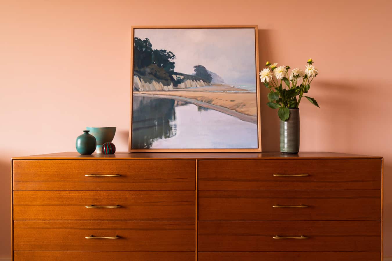 mid century bedroom dresser with framed painting vase of flowers and pottery decor 2