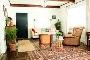 living room scene facing front door with furniture area rugs and vintage decor