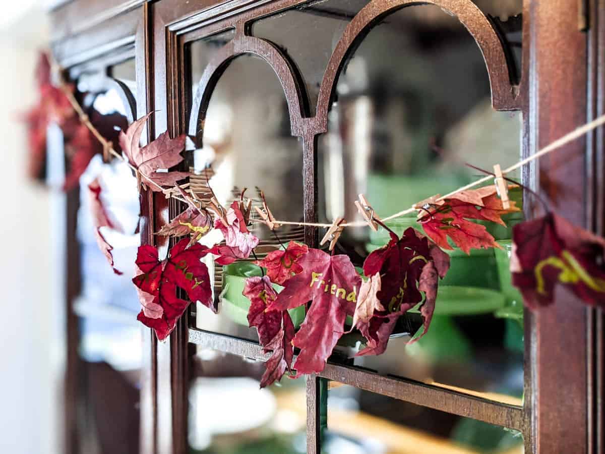 real maple leaf fall garland hanging on a china hutch