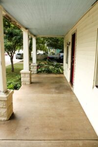 side view of bungalow front porch with pillars and cream siding