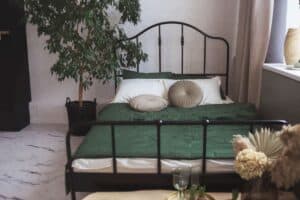 authentic vintage farmhouse iron bed frame with forest green bedding