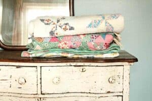 authentic vintage farmhouse antique quilts sitting on top of a distressed vintage dresser