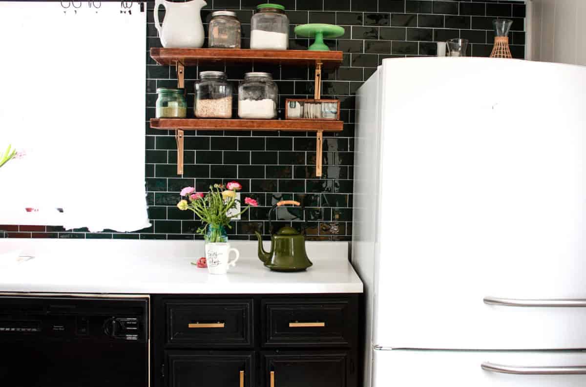 mid century modern mobile home kitchen with vintage styled refrigerator and open shelving