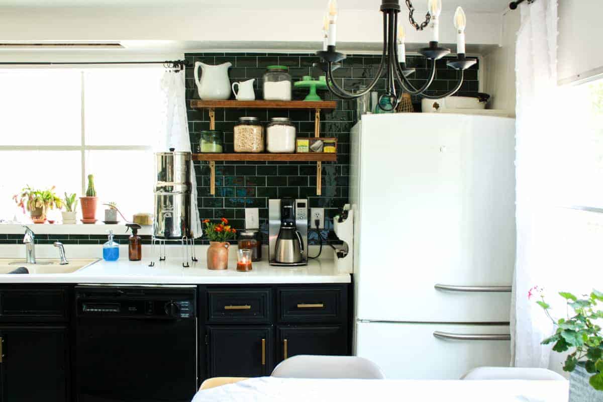 mid century modern mobile home kitchen with vintage styled refrigerator and open shelving