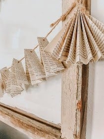 diy song book page garland hung on weathered wooden frame