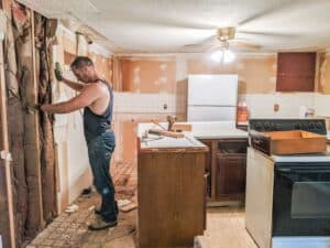 removing old sheetrock from old farmhouse kitchen during renovation