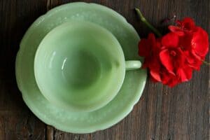 vintage jadeite cup and saucer with red flower for thrift store christmas deocr