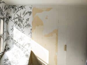 peel and stick wallpaper bathroom panels being applied to mobile home bathroom walls