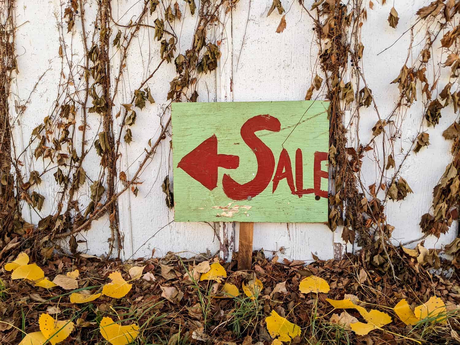 vintage hand painted wooden sign that reads sale with arrow pointing to the left