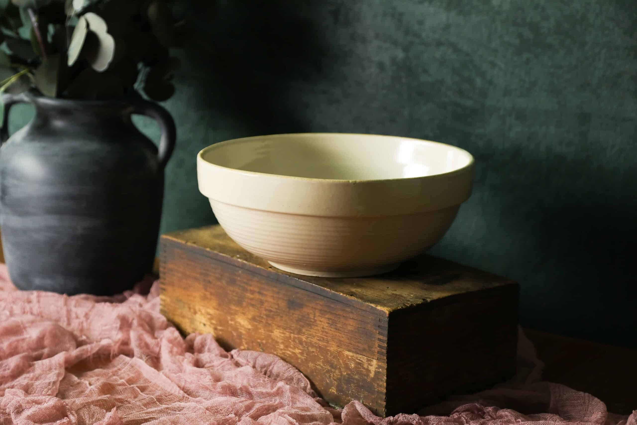 farmhouse ceramic bowl on wooden box against green backdrop